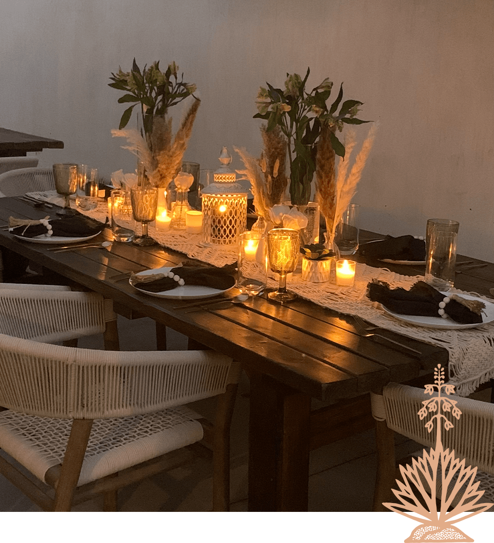 A beautifully set dining table with candles, flowers, and elegant tableware, creating a warm ambiance.